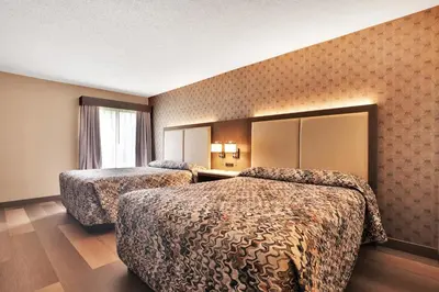 a hotel room with two beds and a mirror at Horizon Inn in Avenel