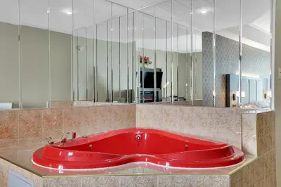 a red tub in a bathroom with a large mirror at Horizon Inn in Avenel