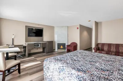 a hotel room with a bed and a desk and a fireplace at Horizon Inn in Avenel