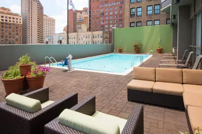 a large swimming pool on a building with chairs and a patio at Holiday Inn Express Philadelphia-Midtown by IHG in Philadelphia