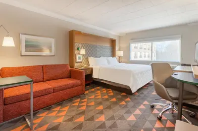 a hotel room with a bed and a couch at Holiday Inn Philadelphia South-Swedesboro by IHG in Swedesboro