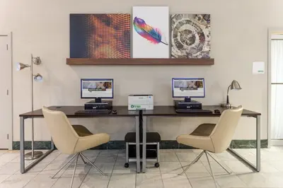 an office with a desk with two computers on it at Holiday Inn Philadelphia South-Swedesboro by IHG in Swedesboro