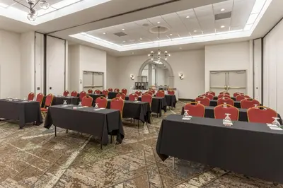 a conference room with tables and red chairs at Holiday Inn Philadelphia South-Swedesboro by IHG in Swedesboro