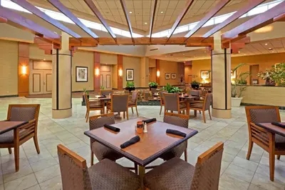 a dining room with tables and chairs at Holiday Inn Philadelphia South-Swedesboro by IHG in Swedesboro