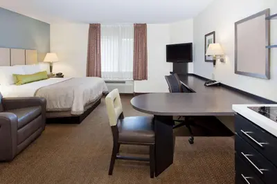 a hotel room with a bed and a desk with a table at Sonesta Simply Suites Philadelphia Mount Laurel in Mount Laurel