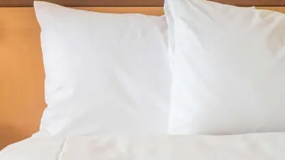 a white pillow sitting on top of a bed at Sonesta Simply Suites Philadelphia Mount Laurel in Mount Laurel