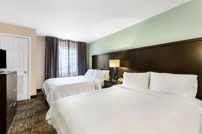a hotel room with two beds and a television at Staybridge Suites-Philadelphia/Mount Laurel by IHG in Mount Laurel