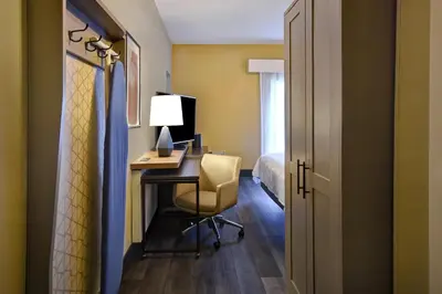 a room with a desk with a chair and a bed at Holiday Inn Philadelphia-Cherry Hill by IHG in Cherry Hill