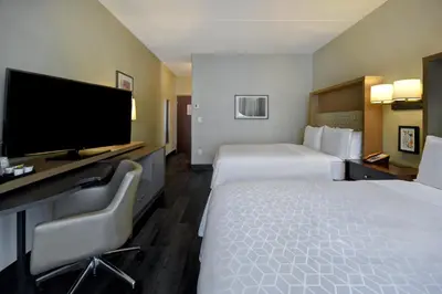 a hotel room with two beds and a flat screen tv at Holiday Inn Philadelphia-Cherry Hill by IHG in Cherry Hill