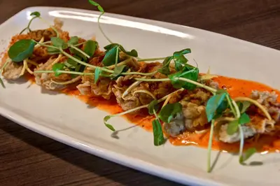 a plate of food with meat and sauce on a table at Holiday Inn Philadelphia-Cherry Hill by IHG in Cherry Hill