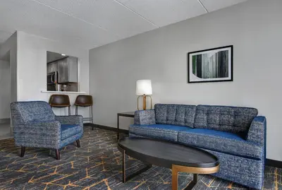 a living room with a couch and a table and chairs at Holiday Inn Philadelphia-Cherry Hill by IHG in Cherry Hill