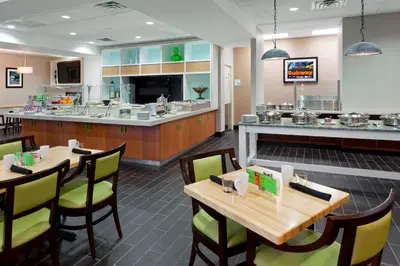 a restaurant with tables and chairs and a counter at Holiday Inn Clark - Newark by IHG in Clark
