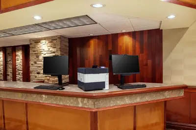 a reception desk with two monitors on top of it at DoubleTree by Hilton Cherry Hill Philadelphia in Cherry Hill