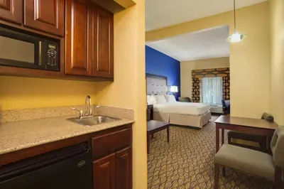 a hotel room with a kitchen and a bedroom at Holiday Inn Express Tower Center New Brunswick by IHG in East Brunswick