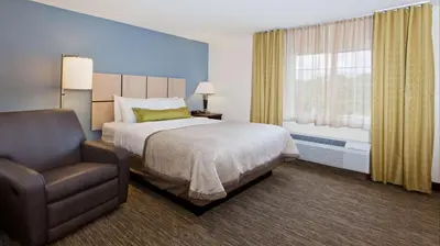 a bedroom with a bed and a chair and a window at Sonesta Simply Suites Nanuet in Nanuet