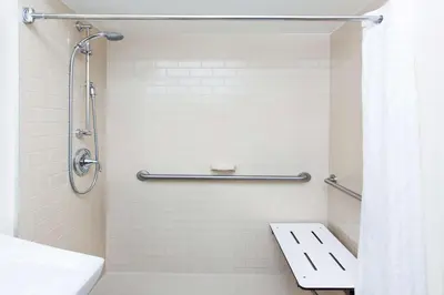a bathroom with a shower with a toilet and a sink at Sonesta Simply Suites Nanuet in Nanuet