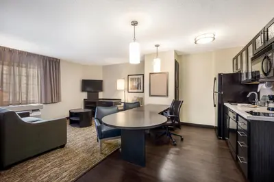 a living room with a table and chairs in a room at Sonesta Simply Suites Nanuet in Nanuet