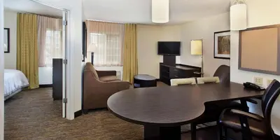 a hotel room with a table and a bedroom at Sonesta Simply Suites Nanuet in Nanuet