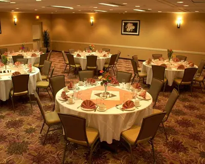 a banquet room with tables and chairs with white tablecloths at Armoni Inn & Suites in Orangeburg