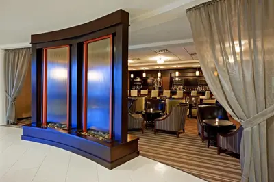 a restaurant with a bar with black tables and chairs at Armoni Inn & Suites in Orangeburg