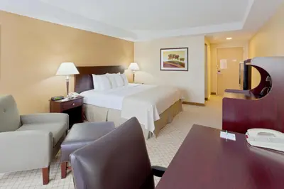 a hotel room with a large bed and a desk at Armoni Inn & Suites in Orangeburg