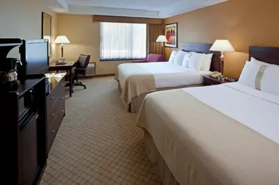 a hotel room with two beds and a flat screen tv at Armoni Inn & Suites in Orangeburg
