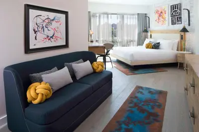 a living room with a couch and a bed at Hotel 50 Bowery, part of JdV by Hyatt in New York