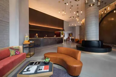 a lobby with a couch and a chair and a table at Hotel 50 Bowery, part of JdV by Hyatt in New York