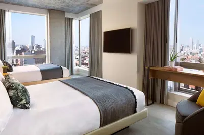 a hotel room with two beds and a large window at Hotel 50 Bowery, part of JdV by Hyatt in New York