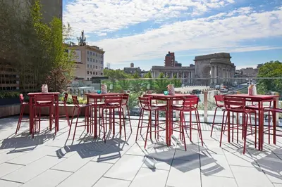 a group of red chairs and tables on a roof at Hotel 50 Bowery, part of JdV by Hyatt in New York