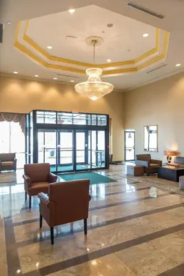 a lobby with chairs and a chandelier in a building at Holiday Inn Hazlet by IHG in Hazlet