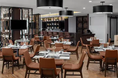 a restaurant with tables and chairs and a bar at Holiday Inn Hasbrouck Heights-Meadowlands by IHG in Hasbrouck Heights