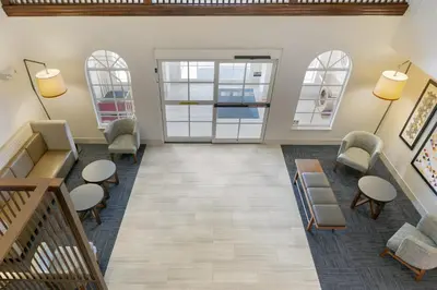 a waiting room with chairs and tables and windows at Holiday Inn Express Mount Arlington by IHG in Mount Arlington