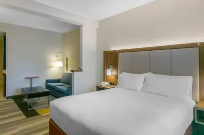 a hotel room with a bed and a blue chair at Holiday Inn Express Mount Arlington by IHG in Mount Arlington