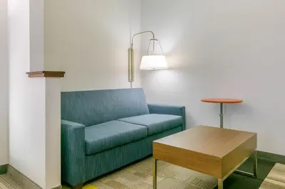a living room with a blue couch and a table at Holiday Inn Express Mount Arlington by IHG in Mount Arlington