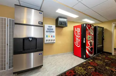 a lobby with two coke machines and a television at Red Roof PLUS Woodbridge - Carteret in Carteret
