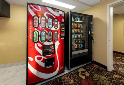 a coca cola vending machine in a room at Red Roof PLUS Woodbridge - Carteret in Carteret