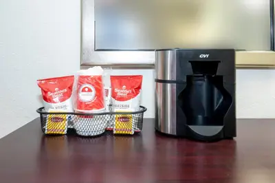 a counter with a coffee maker and a coffee pot at Red Roof PLUS Woodbridge - Carteret in Carteret
