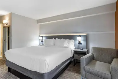 a hotel room with a bed and a chair at Comfort Inn Paramus - Hackensack in Paramus