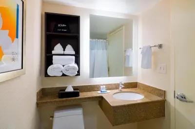 a bathroom with a sink and a toilet and a mirror at Fairfield Inn & Suites by Marriott Paramus in Paramus