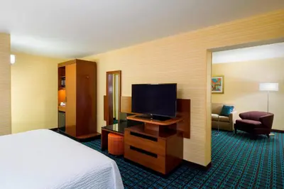 a hotel room with a bed and a flat screen tv at Fairfield Inn & Suites by Marriott Paramus in Paramus