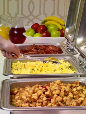 a person is reaching for a tray of food in a refrigerator at Homewood Suites by Hilton Parsippany-Troy Hills in Parsippany