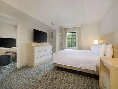 a hotel room with a bed and a flat screen tv at Homewood Suites by Hilton Parsippany-Troy Hills in Parsippany