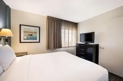 a hotel room with a bed and a flat screen tv at Sonesta Simply Suites Parsippany Morris Plains in Morris Plains