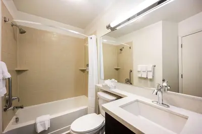 a bathroom with a sink and a tub and a toilet at Sonesta Simply Suites Parsippany Morris Plains in Morris Plains