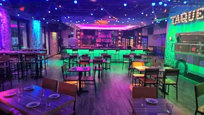 a restaurant with tables and chairs and neon lights at Holiday Inn & Suites Parsippany Fairfield by IHG in Parsippany