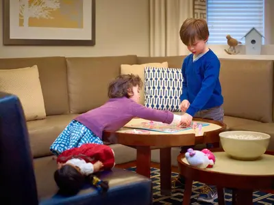 two children playing with a table in a living room at Sonesta ES Suites Somerset in Somerset