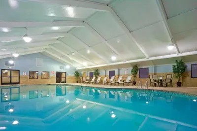 a pool in a hotel with chairs and tables at Holiday Inn South Plainfield-Piscataway by IHG in South Plainfield