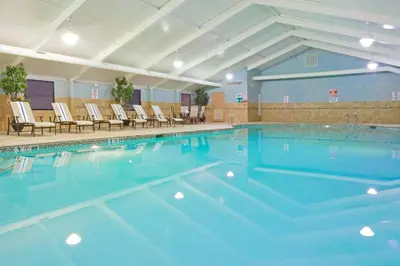 a large swimming pool with chairs in a building at Holiday Inn South Plainfield-Piscataway by IHG in South Plainfield