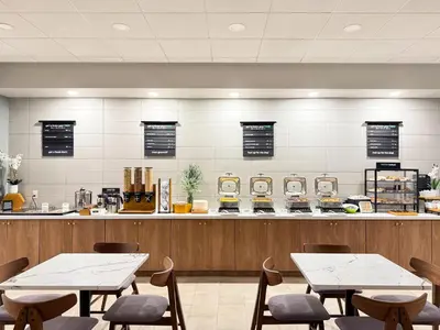 a restaurant with two tables and a counter at Holiday Inn South Plainfield-Piscataway by IHG in South Plainfield